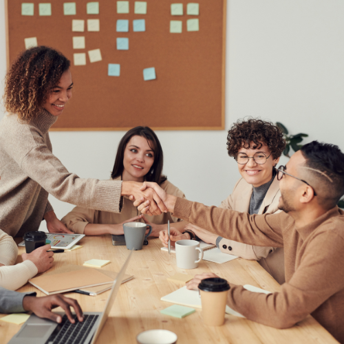 People collaborate and shake hands in an office - Media Production Jobs